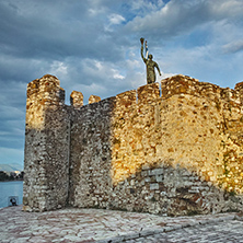 Sunset at port of Nafpaktos town and monument over Castle wall, Western Greece