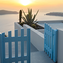 Entrance of white house and sunset in town of Imerovigli, Santorini island, Thira, Cyclades, Greece