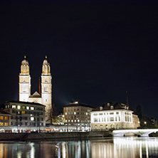 Night photo of Grossmunster church and bridge over Limmat River, city of Zurich, Switzerland