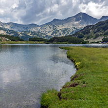 Green Grass and Banderishki Chukar Peak and reflection in Muratovo lake, Pirin Mountain, Bulgaria
