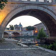 Amazing Sunset view of Tiber River, St. Angelo Bridge and St. Peter"s Basilica in Rome, Italy