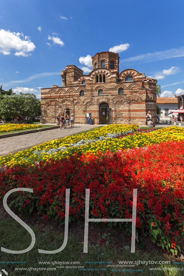 NESSEBAR, BULGARIA - AUGUST 12, 2018: Flower garden in front of Ancient Church of Christ Pantocrator in the town of Nessebar, Burgas Region, Bulgaria