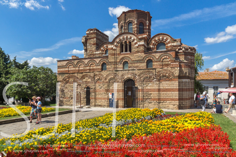 NESSEBAR, BULGARIA - AUGUST 12, 2018: Flower garden in front of Ancient Church of Christ Pantocrator in the town of Nessebar, Burgas Region, Bulgaria